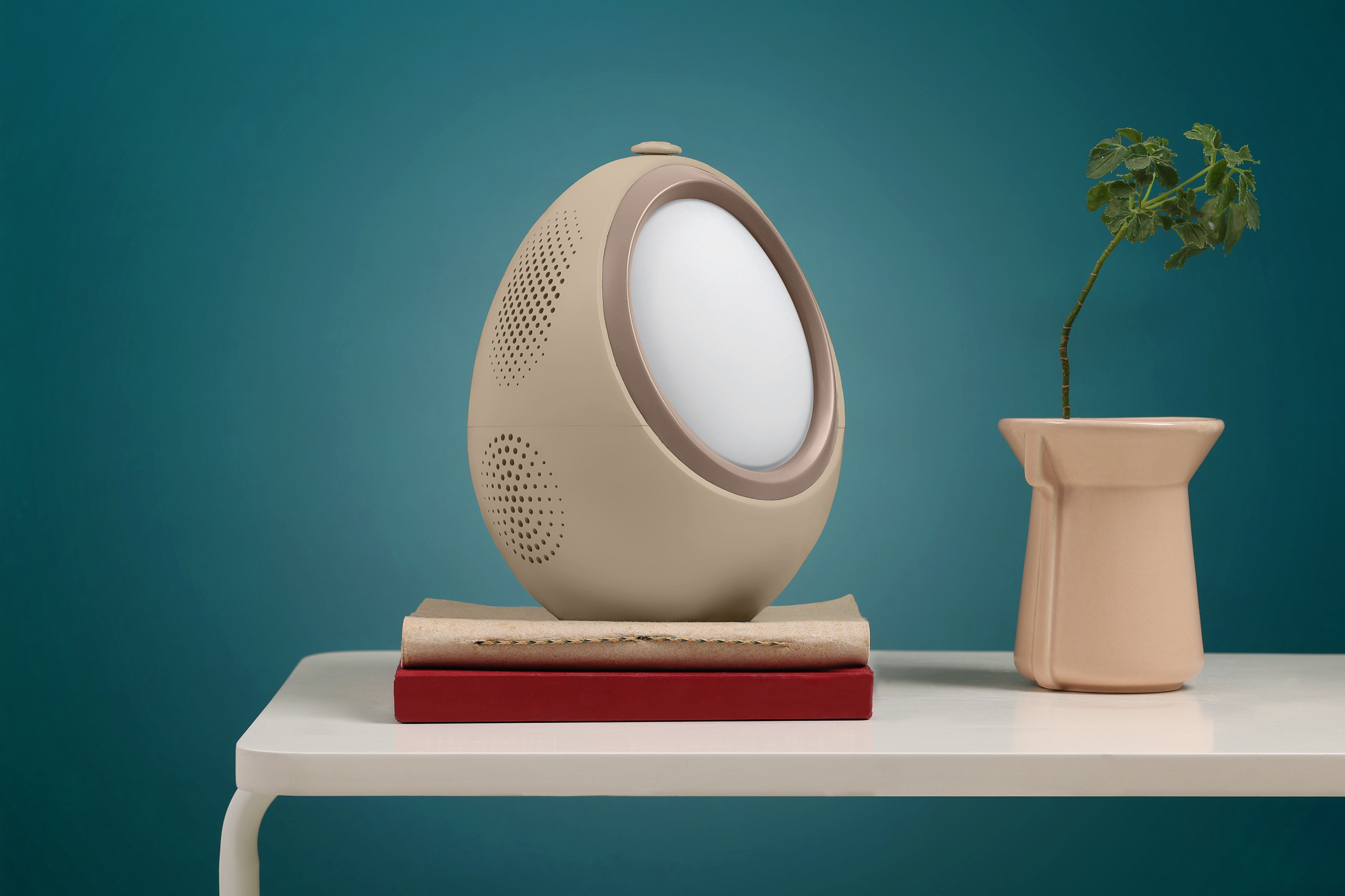 beige AI sleep device by Naptick with speaker and light placed on table for better sleep experience